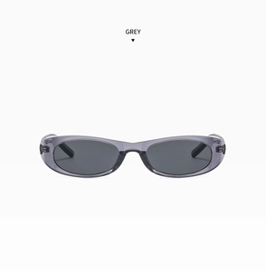 Close-up of retro oval grey sunglasses with translucent frames and dark grey lenses