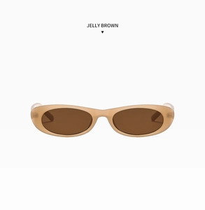 Detail view of oval jelly brown sunglasses with translucent resin frames and dark lenses