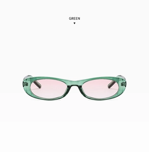 Detail view of oval sunglasses with transparent green resin frame and purple tinted lenses