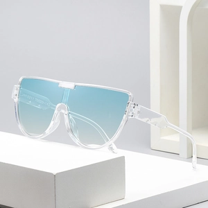 Occhiali da sole oversize con lenti blu sfumate e montatura trasparente su blocchi bianchi