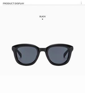 Detail view of glossy black round frames and dark lenses for retro sunglasses