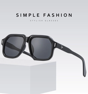 Detail of square black sunglasses with metal rivet accents on geometric white stands