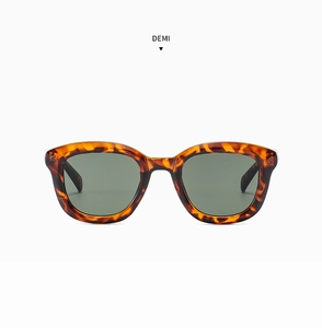 Detailed view of demi patterned retro round sunglasses with dark lenses on white background
