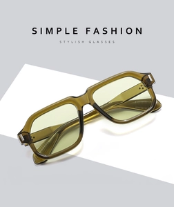 Detail view of retro aviator sunglasses featuring transparent olive green frames and yellow lenses
