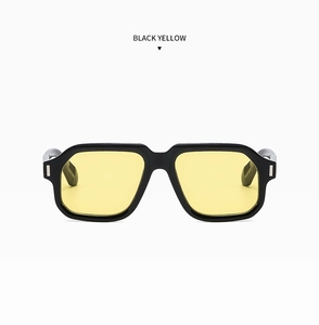 Close-up of black retro oversized square sunglasses with transparent yellow lenses