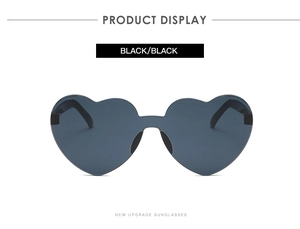 Close-up of frameless black heart-shaped sunglasses with a sleek one-piece lens design