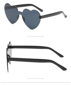 Detail view of black rimless heart-shaped sunglasses with sleek plastic temples