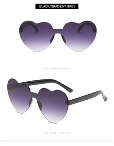 Detail view of heart-shaped rimless sunglasses with black frames and gradient grey lenses