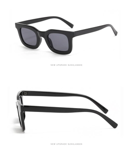 Vue latérale détaillée des lunettes de soleil noires à monture épaisse et branches larges