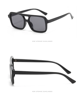 Detail view of double-bridge pilot sunglasses with black frame and dark grey lenses