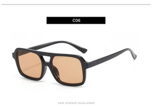 Detail of retro oversized black sunglasses with double bridge and amber lenses
