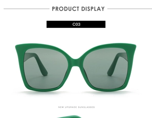 Detail view of bright green cat eye sunglasses frames with high-quality grey lenses