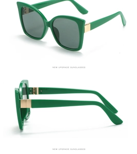 Detail view of emerald green cat-eye sunglasses with golden metal hinges and dark grey lenses
