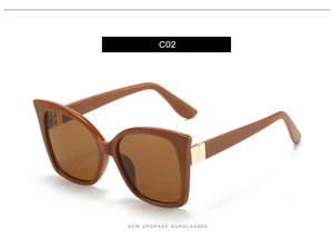 Close-up of caramel square sunglasses featuring golden metal accents on the hinge