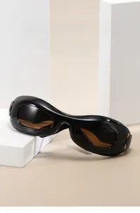 Close-up of black Y2K sunglasses with thick frames and golden triangle metal hinges