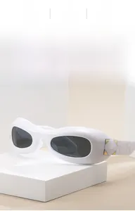 Detail of white Y2K thick frame sunglasses with golden metallic triangles and textured temples
