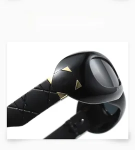 Macro detail of black Y2K sunglasses with golden metal insert and quilted pattern temples