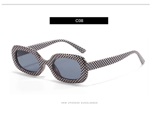 Makroaufnahme einer oval-rechteckigen Sonnenbrille mit modischem Schachbrettmuster-Rahmen