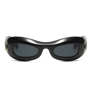 Futuristic Y2K punk sunglasses with thick black oval frames and gold metal accents