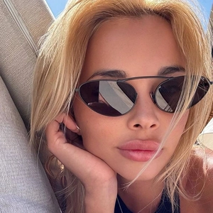 Close-up of black oval punk sunglasses with thin metal frames and double bridge detail