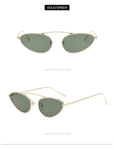 Detail view of oval punk sunglasses with gold metal frame and dark green lenses