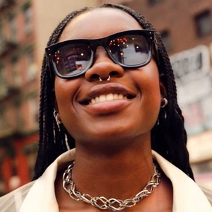 Nahaufnahme einer Retro-Sonnenbrille mit geflochtener Silberkette an einem Model
