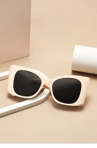 Vue détaillée des lunettes de soleil rectangulaires crème à branches larges sur support