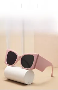 Gros plan de lunettes de soleil à monture rose épaisse avec des verres foncés