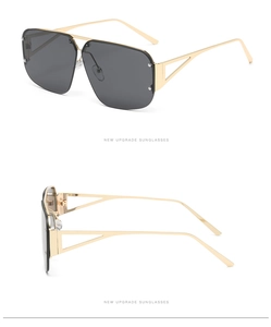 Detail of square oversized sunglasses with gold metal temples and triangular hollow design