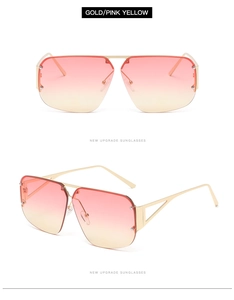Detail of square gold metal sunglasses with pink yellow gradient lenses and side cut-outs