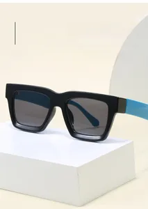 Detail view of square black frames with contrasting bright blue temples on a white pedestal
