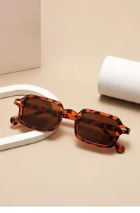 Detail of square tortoiseshell sunglasses with brown lenses and golden metal accents