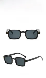 Detail of square black sunglasses with gold metal accents on temples from two angles