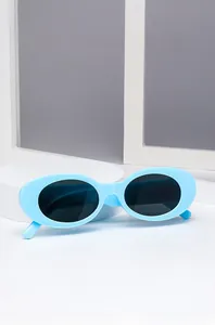 Detail of retro oval sunglasses with light blue frames and dark lenses on a pedestal