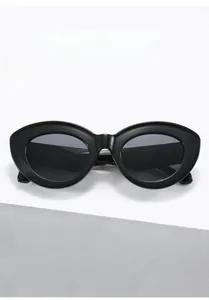 Close-up of black oval sunglasses with thick frames and premium anti-glare dark lenses