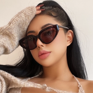 Close-up of retro small frame cat eye sunglasses with dark lenses on female model