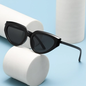 Retro small frame cat-eye sunglasses in black finish on blue background with white props
