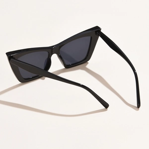 Classic black cat-eye sunglasses for women with dark lenses on a clean beige surface