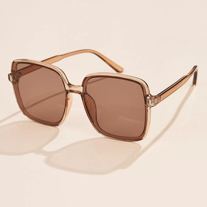 Detailed close-up of brown oversized square sunglasses with transparent resin frames