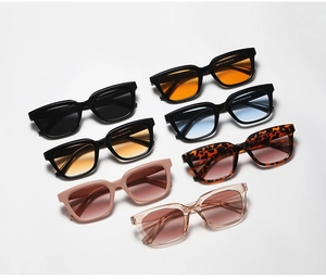 Flat lay of small square sunglasses in seven assorted colors with gradient ocean lenses