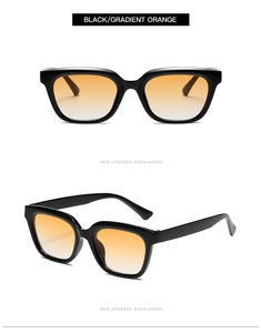 Close-up of small square sunglasses with thick black frames and gradient orange lenses