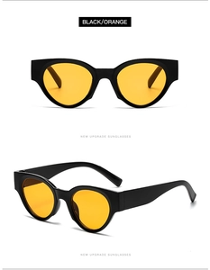 Dettaglio degli occhiali da sole cat-eye neri con lenti arancioni per un look retrò