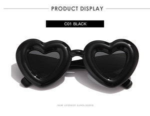Gros plan de lunettes de soleil coeur noir avec monture épaisse et brillante en noir C01