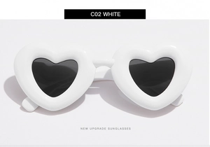 Vue détaillée de lunettes de soleil blanches en forme de cœur avec monture épaisse