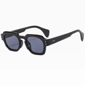Detailed close-up of thick black polygon sunglasses with silver metal rivets on the side