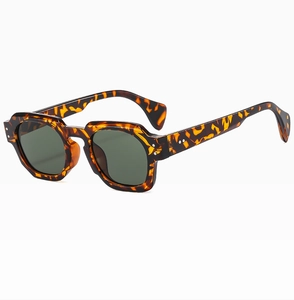 Detail view of retro tortoiseshell sunglasses with green lenses and silver studs