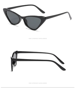 Detail view of glossy black cat-eye sunglasses featuring dark grey lenses and NEW UPGRADE text