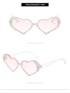 Detail view of heart-shaped sunglasses with pink gradient lenses and rhinestone-encrusted frames