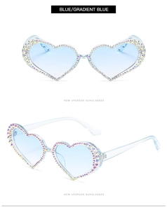 Detail of heart-shaped sunglasses with gradient blue lenses and colorful rhinestones
