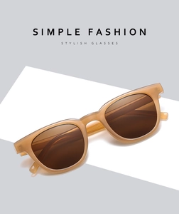 Close-up of translucent amber square sunglasses with dark brown lenses on minimalist background